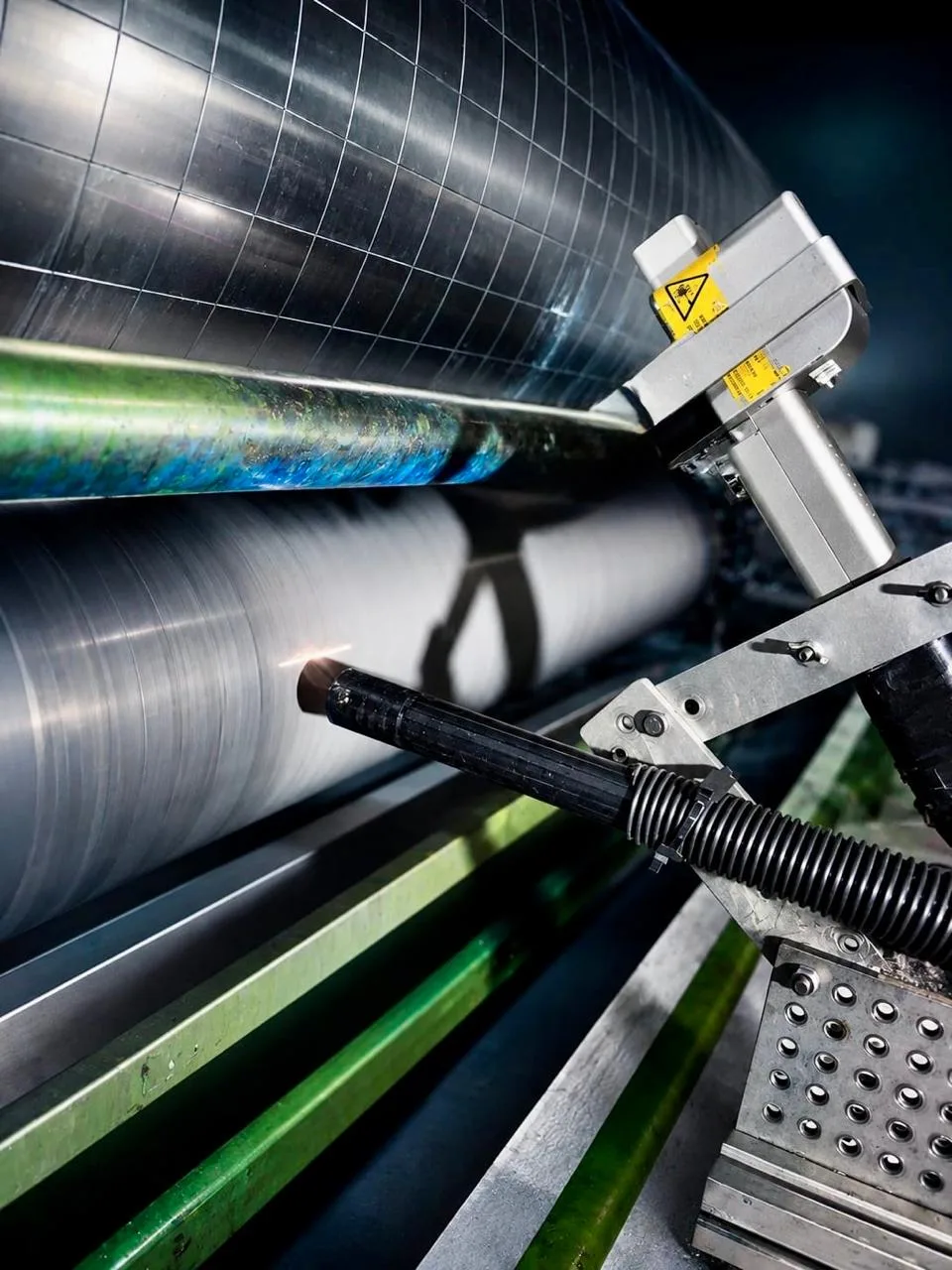 Laser cleaning head removing contamination from an anilox roller on a press